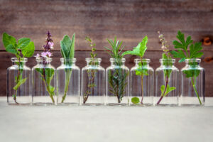 Bottle of essential oil with herbs holy basil flower, basil flow